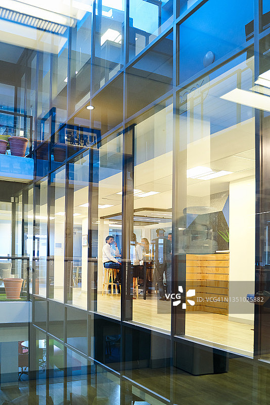 下班后商务人士在办公室大堂咖啡馆交谈图片素材