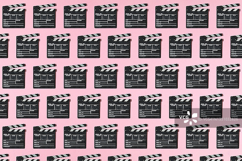 木制老电影拍板图案与硬阴影在粉红色的背景。电影工业、电影、娱乐和好莱坞的概念。图片素材