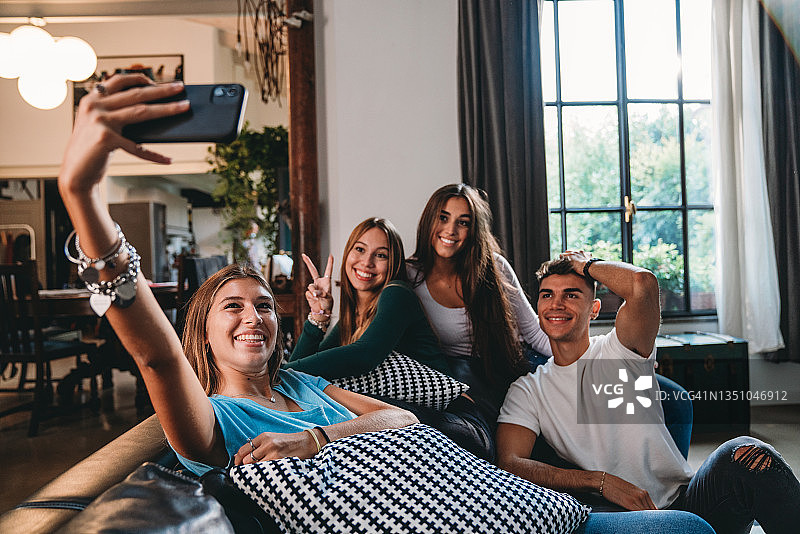 四个青少年朋友在家里的沙发上自拍图片素材