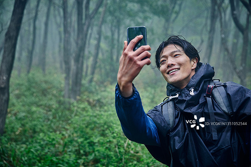 一名男子在徒步旅行时进行视频通话图片素材