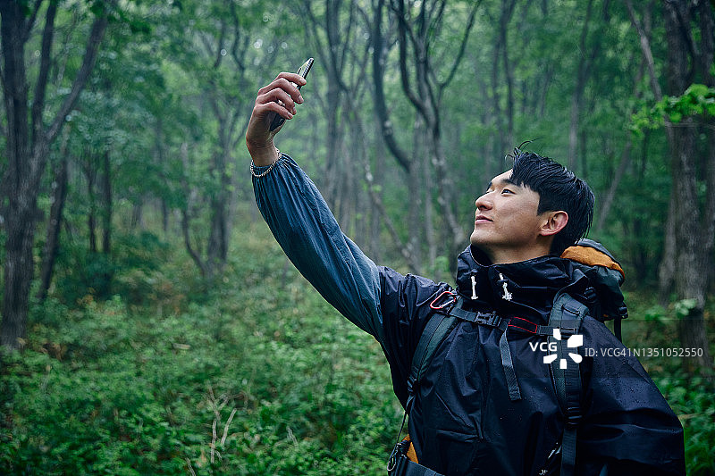 一名男子在徒步旅行时进行视频通话图片素材
