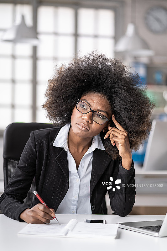 在办公室一天结束时，因心理压力而苦恼的年轻非裔美国女商人，解决案件并思考决策图片素材