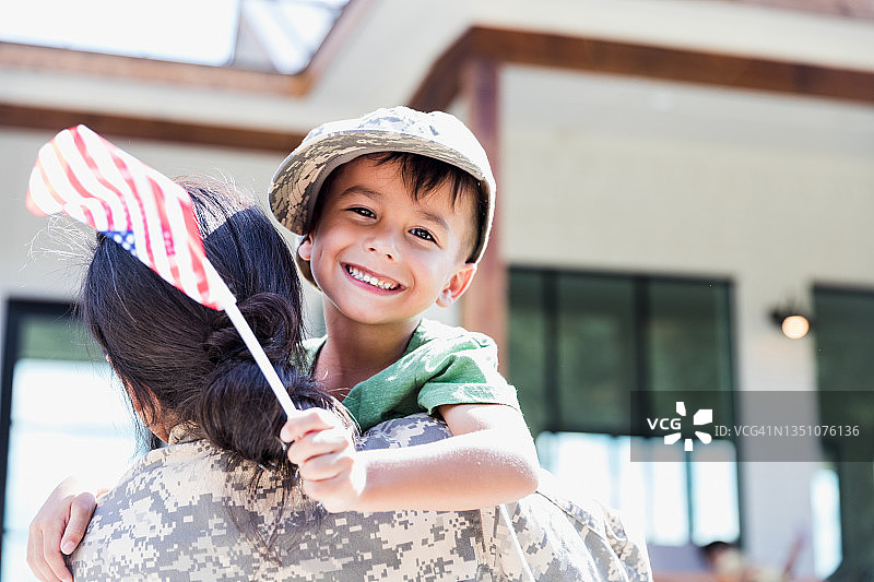 抱着微笑男孩的模糊女兵，手持旗帜图片素材