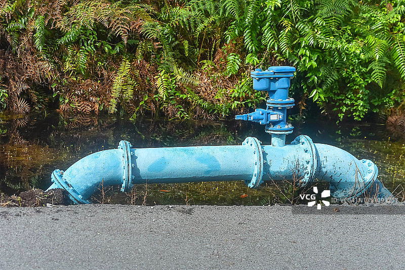 特写：马来西亚砂拉越诗巫乡村道路旁的巨型金属地上水管图片素材