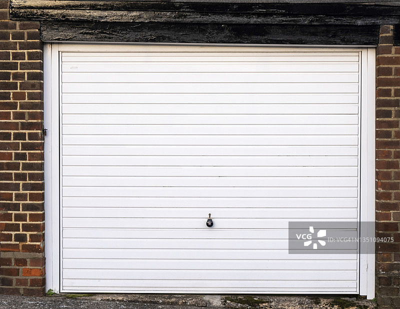 砖砌环境中的白色车库门图片素材