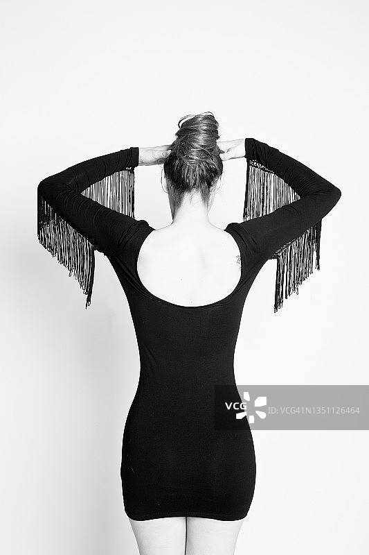 迷人女子身穿流苏小黑裙，梳着发髻的背影图片素材