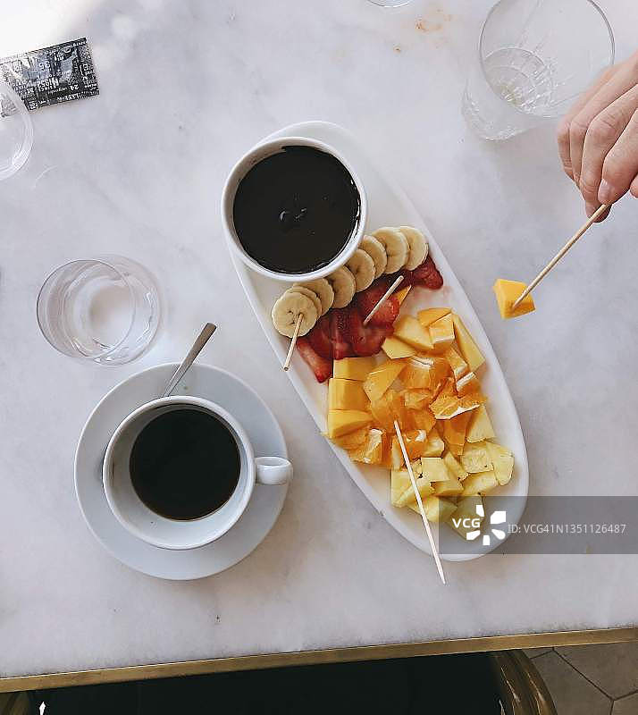 吃巧克力水果火锅喝咖啡的人俯视图图片素材