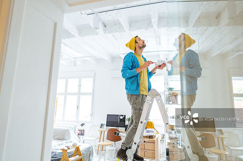 电工修理天花板灯图片素材