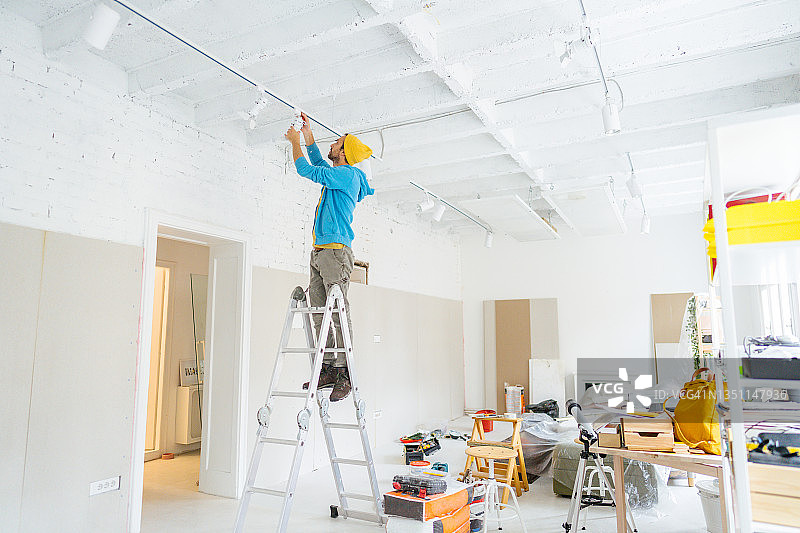 电工修理天花板灯图片素材