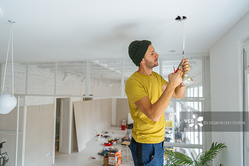 电工修理天花板灯图片素材