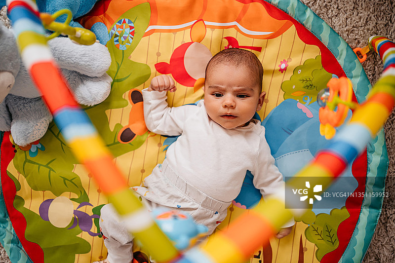 躺在彩色游戏垫上的男婴图片素材