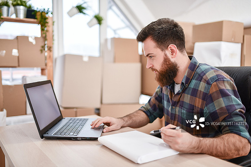 男子在快递点专注打包准备寄送的包裹图片素材