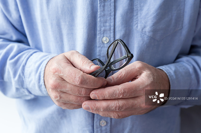 一位老人手中的眼镜特写图片素材
