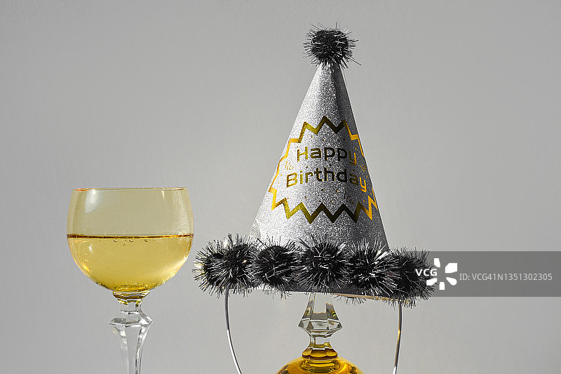 一杯戴着生日帽的香槟图片素材