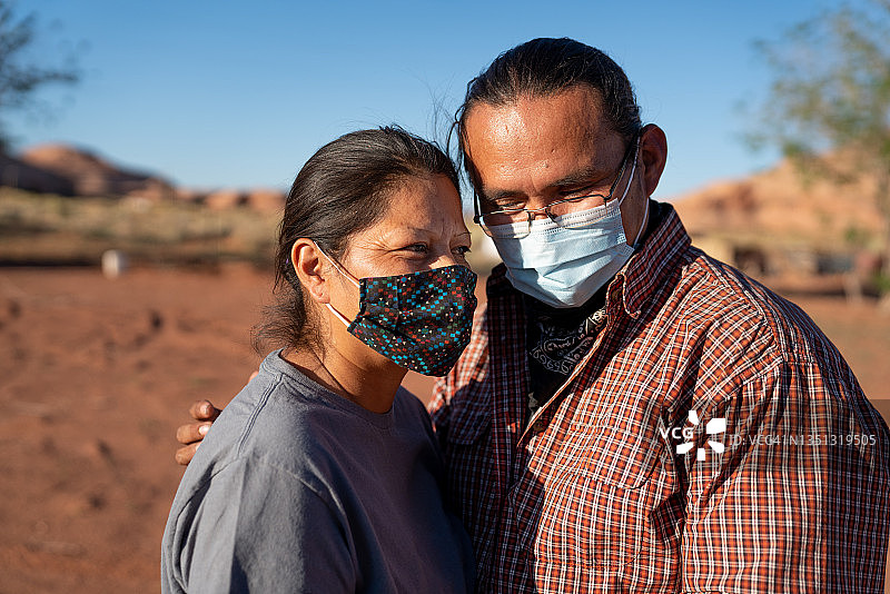 在纪念碑谷部落公园佩戴新冠口罩的年轻纳瓦霍族夫妇图片素材