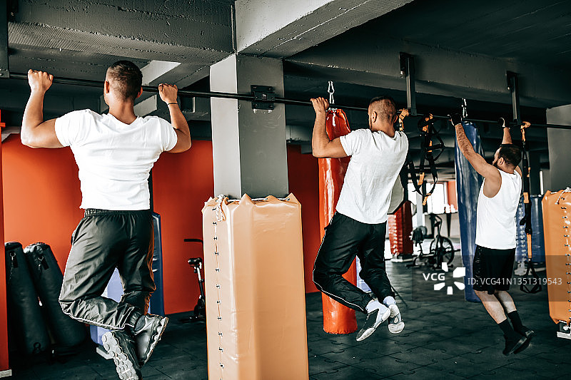 男性运动员在健身房做引体向上图片素材
