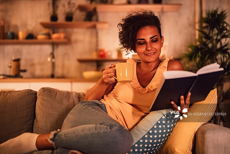 女人躺在沙发上看书图片素材