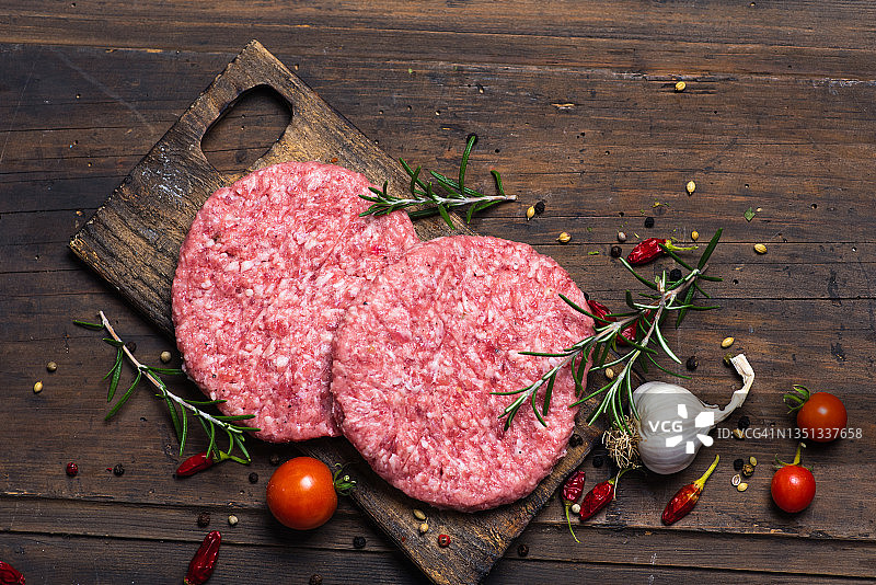 木质背景上的两个未烤汉堡图片素材