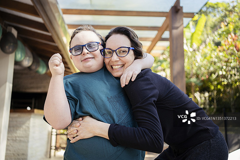 患有唐氏综合征的母子在后院的肖像图片素材