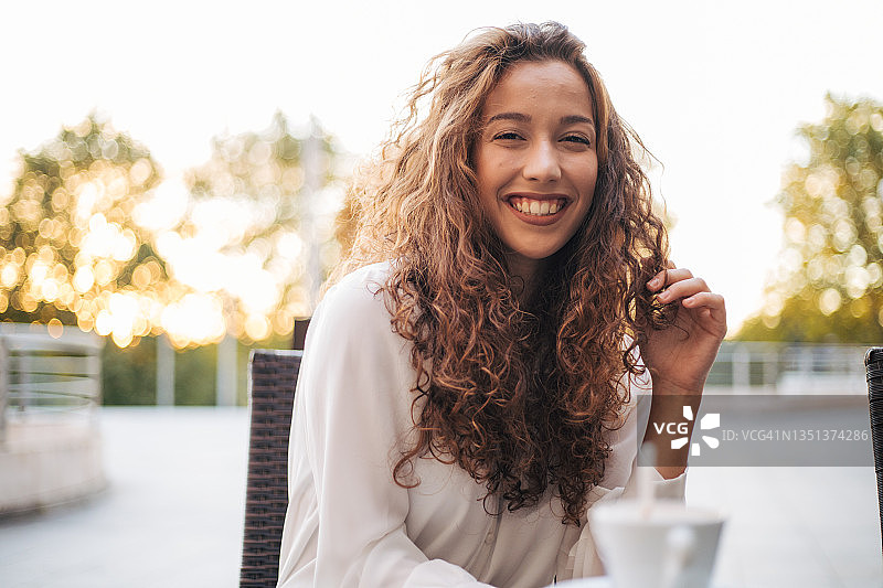 在咖啡馆里享受卡布奇诺的女人图片素材