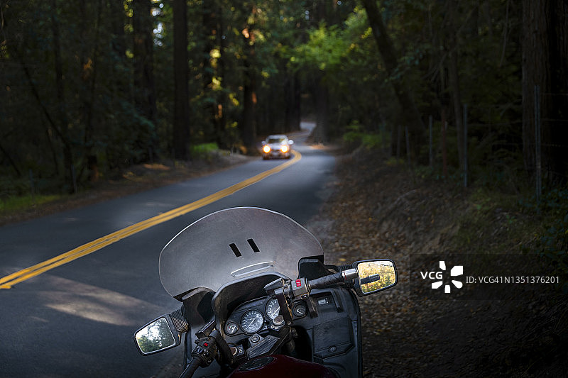 森林乡村公路上的摩托车和小汽车图片素材