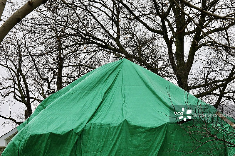 覆盖风暴受损建筑物的塑料防水布图片素材