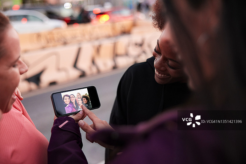一群女人在智能手机上分享照片和社交媒体图片素材