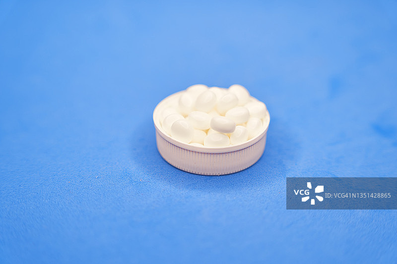 装满白色药丸的药盒盖子特写图片素材