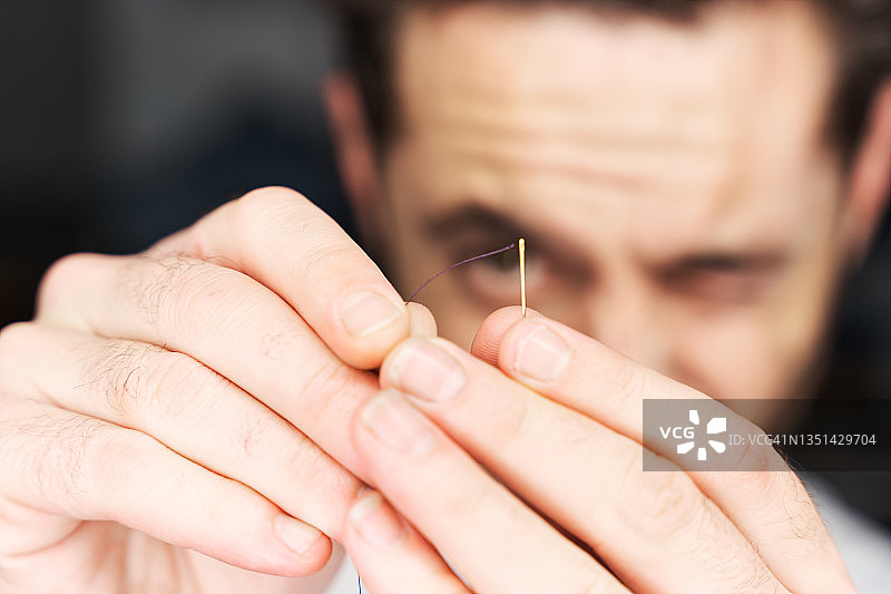 男人穿针引线特写图片素材