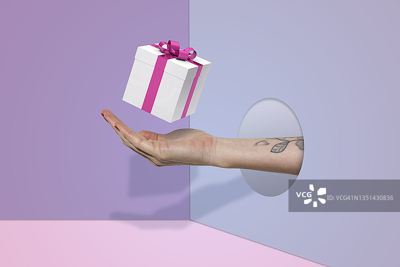 女人在超现实背景下手捧礼品盒图片素材