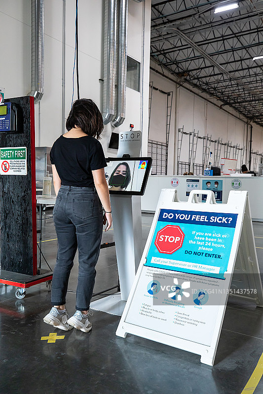 在仓库入口使用热成像扫描仪的女人图片素材