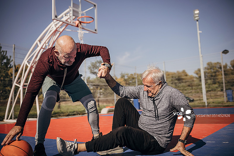 年长的男人在篮球场上腿部受伤图片素材