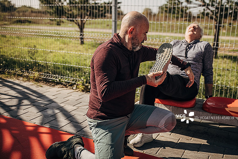 年长的男人在篮球场上腿部受伤图片素材