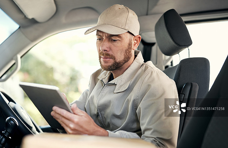 英俊的成熟快递员挨家挨户地用货车送包裹图片素材