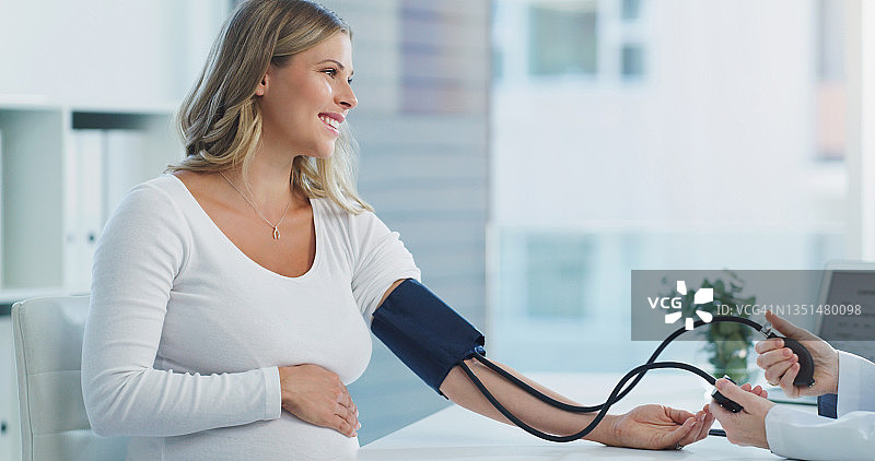 医生在咨询期间检查孕妇血压的照片图片素材