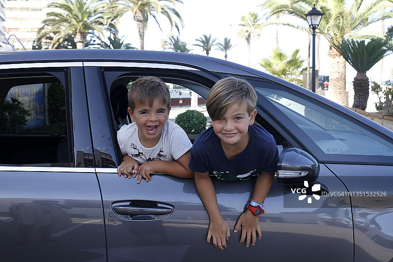 在自驾游中，兄弟姐妹在车里向外看图片素材