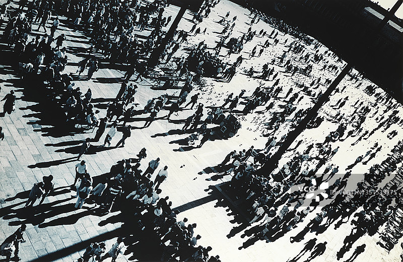 阳光明媚的城镇广场上的剪影人群图片素材