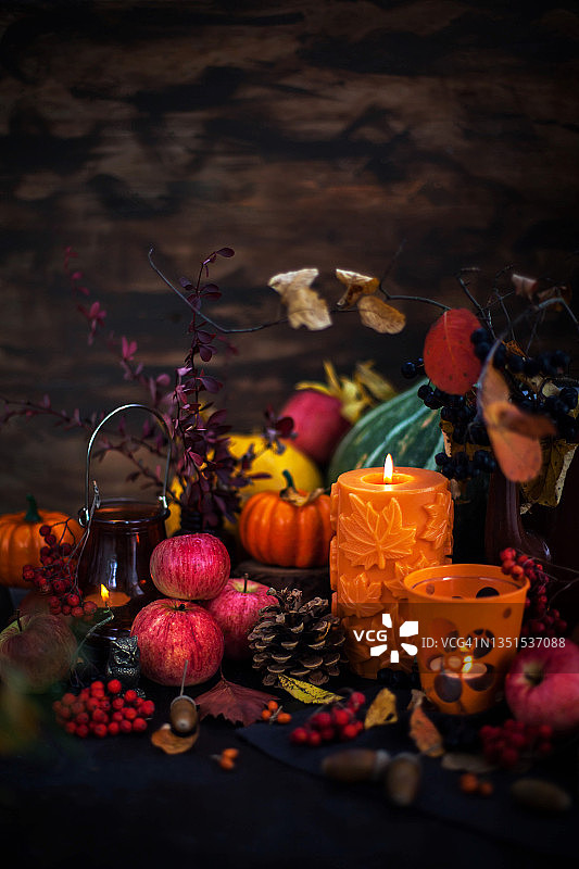 秋季静物与桌面装饰：南瓜、苹果、花楸、蜡烛、落叶图片素材