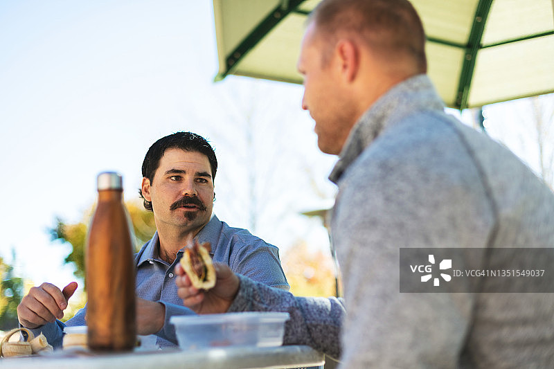 工作午休期间吃健康食品和交流的年轻男性系列照片图片素材