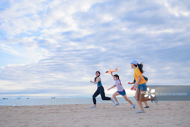 一群姐妹在海滩上一起奔跑，放飞火箭图片素材
