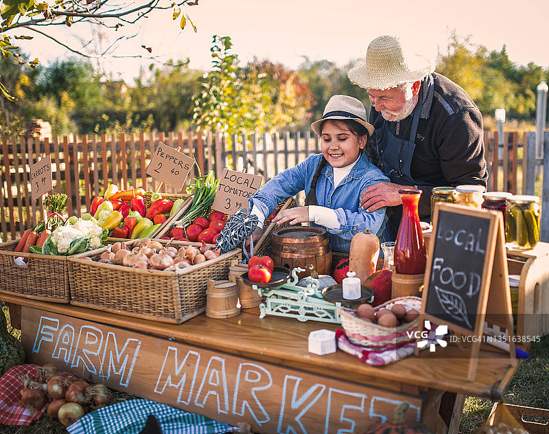 农场工人在市场摊位上出售自家种植的食品图片素材