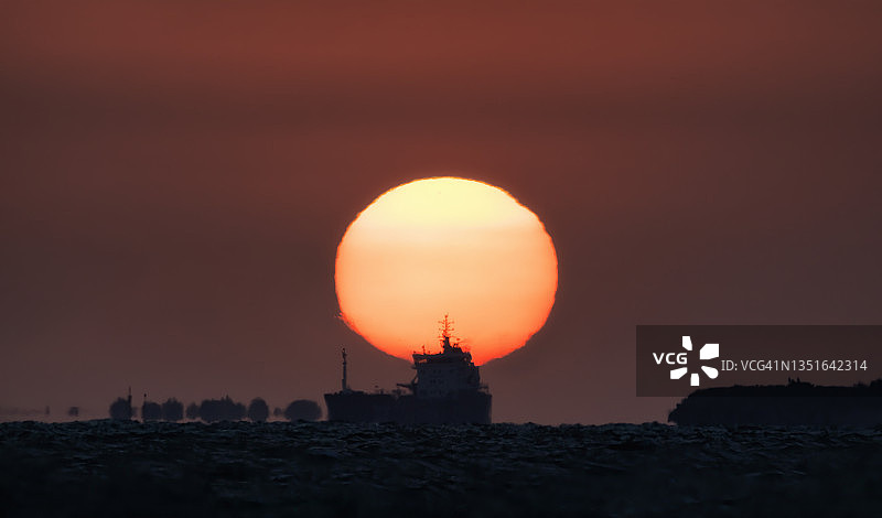 海上日落：落日余晖映衬下的船只图片素材
