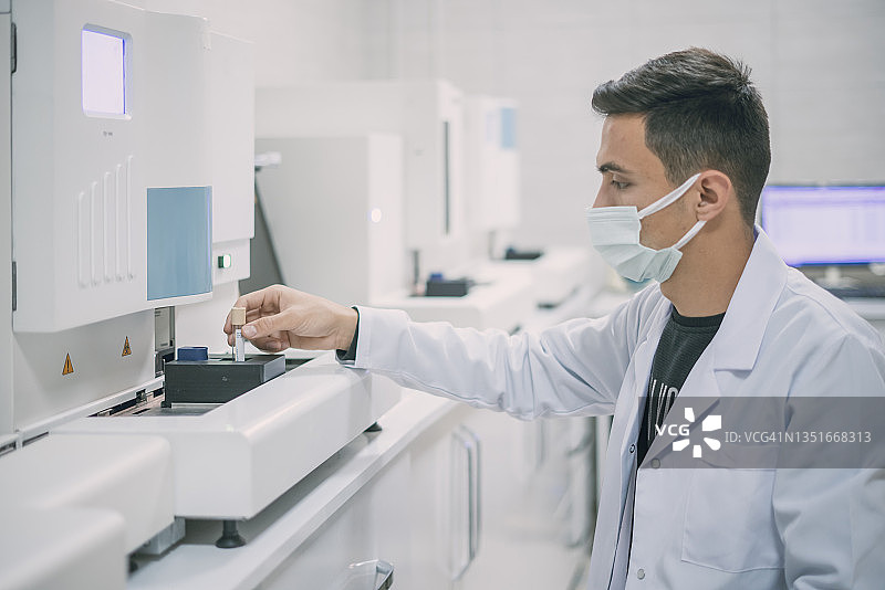 在实验室工作的科学家，正在操作生化机器图片素材