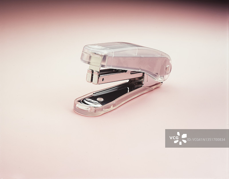 粉色背景上的小型订书机图片素材