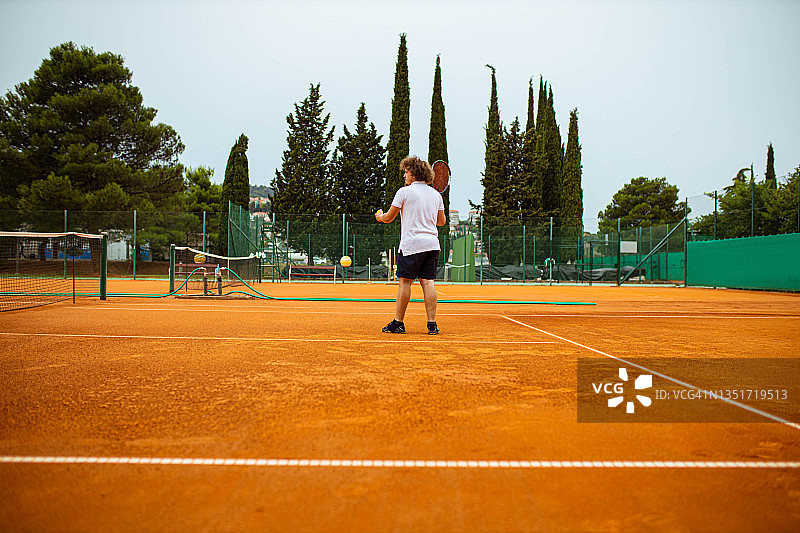 专业男网球运动员在红土球场网球比赛中发球图片素材