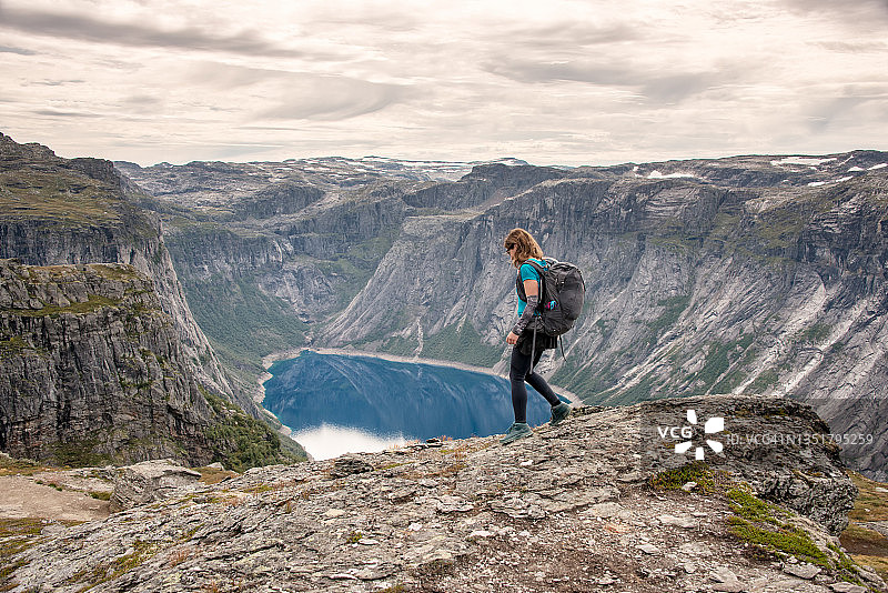 挪威徒步：巨人之舌附近的岩石顶上的运动型女人图片素材