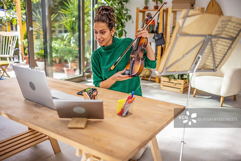 年轻女子参加在线小提琴课程图片素材