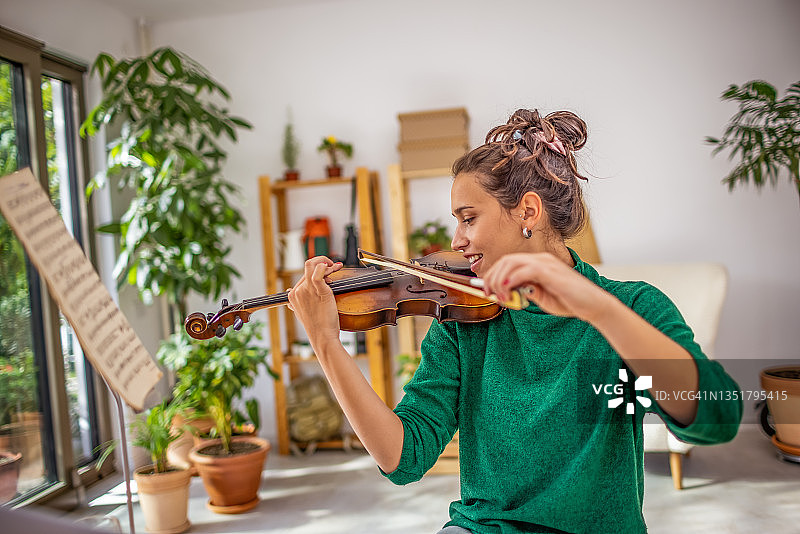在家拉小提琴的年轻女子图片素材