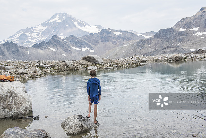 冰川峰荒野区高山湖泊旁的男孩图片素材