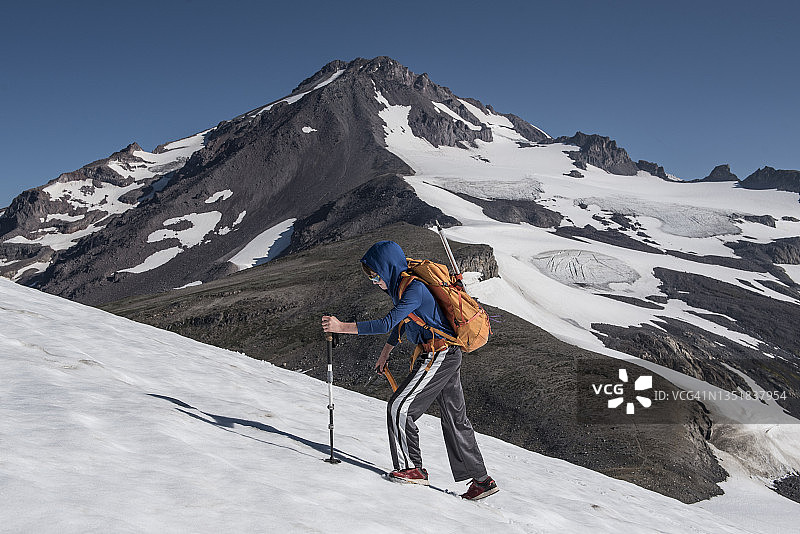 男孩在冰川峰荒野的雪地上徒步旅行图片素材